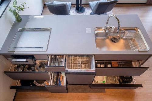 a kitchen with a counter with a sink and cabinets at STARRY The Garden Hakuba Iwatake in Hakuba