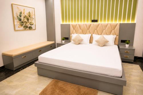 a bedroom with a large bed and a bench at Hotel Ramkesarrai in Ayodhya