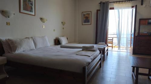 ein Hotelzimmer mit zwei Betten und Balkon in der Unterkunft Studios Gelly's in Gythio