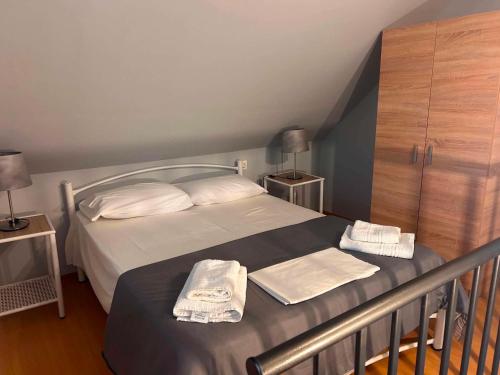 a bedroom with a bed with towels on it at Άνεμος Home 2 in Kavála