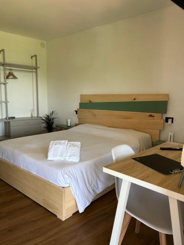 a bedroom with a large bed and a table at Da Noi Panoramic Guest Stay Camera Orizzonte in Cuorgnè