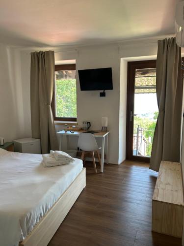 a bedroom with a bed and a desk and a television at Da Noi Panoramic Guest Stay Camera Orizzonte in Cuorgnè