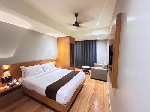 a hotel room with a bed and a television at Hashtag Inn opposite Sarusajai Stadium in Guwahati