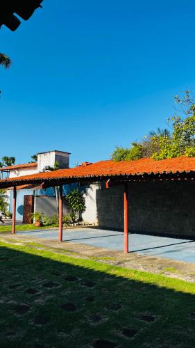 a pavilion with an orange roof next to a street at Pousada Brisa do Oceano - Cumbuco in Cumbuco