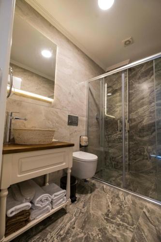 a bathroom with a shower and a toilet and a sink at İcarus Alaçatı in Çeşme