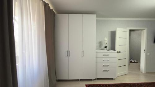 ein Schlafzimmer mit einem weißen Schrank und einer Kommode in der Unterkunft The Pristine Elegance in Chişinău