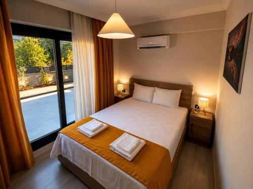 a bedroom with a bed and a large window at Olivara Suites in Fethiye