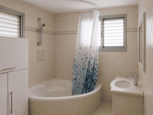 a bathroom with a tub and a sink at נוף יבנאל in Yavneʼel
