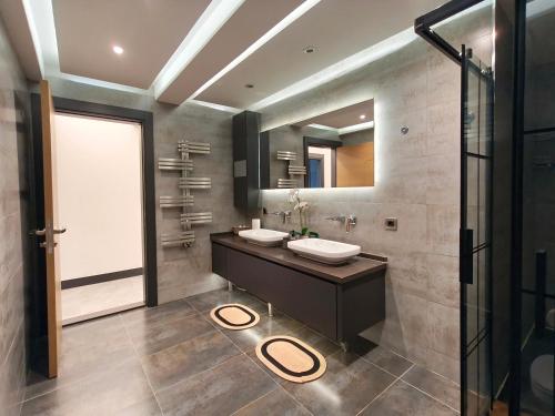 a bathroom with two sinks and a large mirror at Utopia Suite Residence - 4 Bedroom Apartment in Burunabat