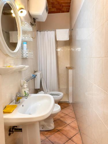 a bathroom with a white sink and a toilet at La Piccola dimora in Gambassi Terme