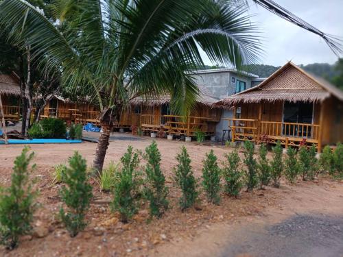 a house with a palm tree in front of it at Long Beach Bamboo House in Ban Ai Dao