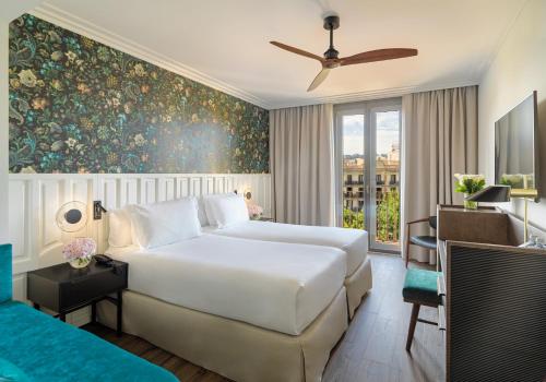 a bedroom with a large white bed and a window at H10 Casanova in Barcelona