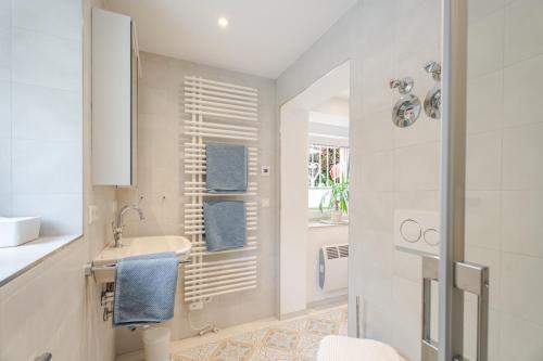 a white bathroom with a sink and a mirror at Villa Rosa in Offenburg