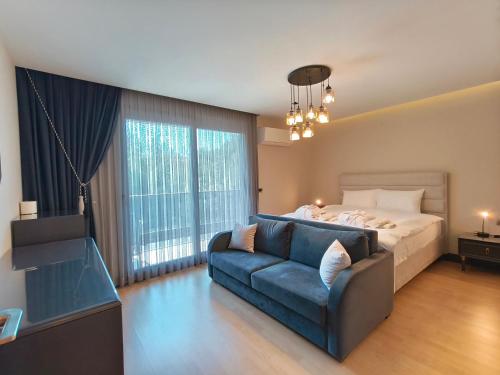 a bedroom with a bed and a blue couch at Utopia Suite Residence - 4 Bedroom Apartment in Burunabat