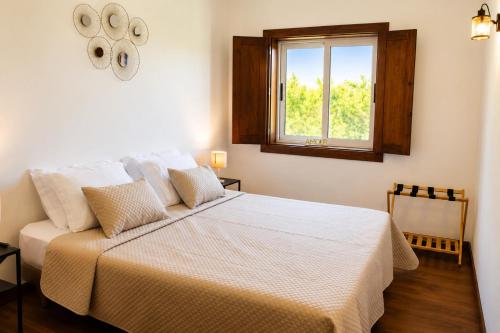 a white bed in a room with a window at Pouso Du'Vagar in Cuba
