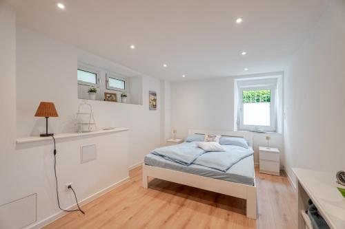 a white bedroom with a bed and a window at Villa Rosa in Offenburg