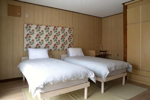 two beds sitting next to each other in a room at 大磯シーサイドハウス 海まで2分 駅近の一軒家 in Oiso