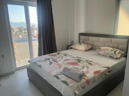 a bedroom with a bed with a view of a balcony at Ida Apartments in Sarandë