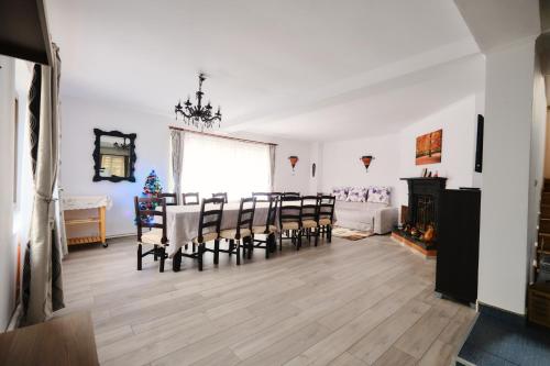 a dining room with a table and chairs and a christmas tree at Vila Residence in Moieciu de Sus