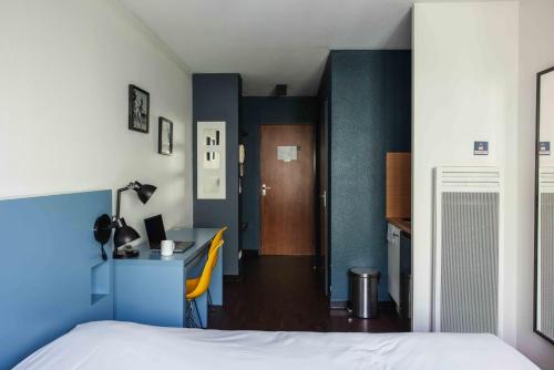 a bedroom with a bed and a desk and a room at Ténéo Apparthotel Bordeaux - Gare Saint Jean in Bordeaux