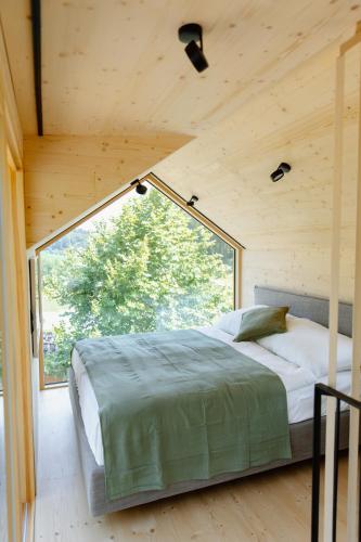 a bed in a room with a large window at OFF Living Charlet in Pirching am Traubenberg