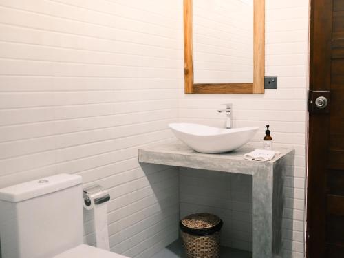 a white bathroom with a sink and a toilet at Ethera Arugam bay in Arugam Bay