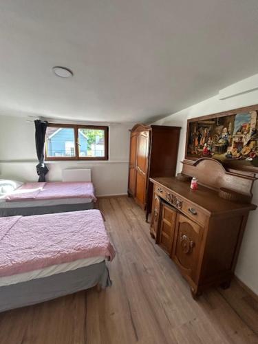 a room with two beds and a wooden floor at myappart - FORBACH in Forbach