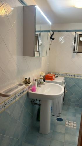 a bathroom with a white sink and a mirror at A casa di nonna Elvira in Vietri sul Mare
