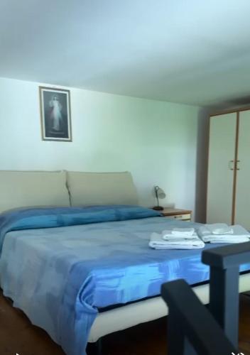 a bedroom with a bed with blue sheets and a table at A casa di nonna Elvira in Vietri sul Mare