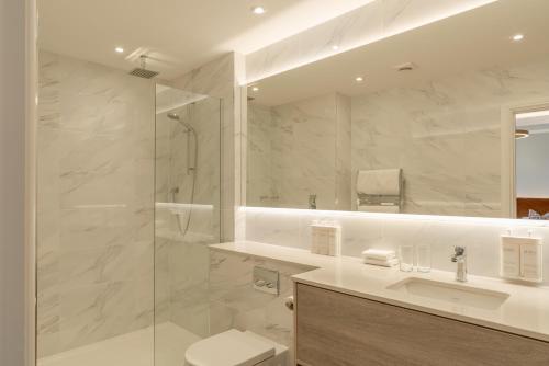 a bathroom with a shower and a toilet and a sink at The Inn On The Lake in Glenridding