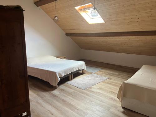 a attic room with two beds and a window at Sporting Pyrenées House in Vicdessos