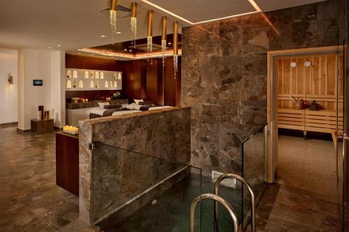 a lobby with a stone wall and a bar at Parklane, a Luxury Collection Resort & Spa, Limassol in Limassol