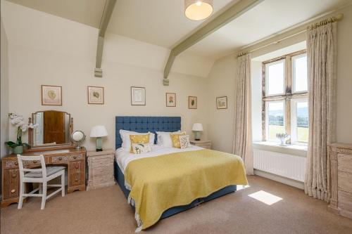 a bedroom with a bed and a dresser and a window at Hollins Farmhouse in Leyburn