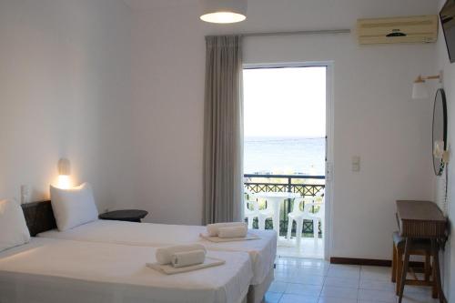 two beds in a room with a view of the ocean at Paradise Beach Apartments in Argassi