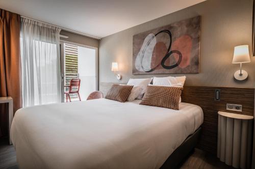 a large white bed in a hotel room at Thalazur Carnac in Carnac
