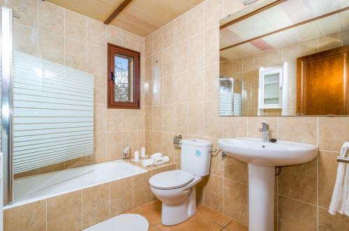 a bathroom with a toilet and a sink and a tub at Son Fred in Felanitx
