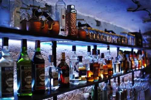 a shelf filled with lots of bottles of alcohol at Cinema Rooms - Piotrkowska in Łódź