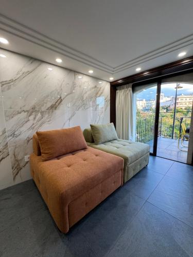 ein Sofa in einem Zimmer mit einer Marmorwand in der Unterkunft B in Byblos in Byblos