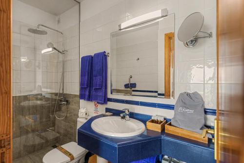 a bathroom with a blue sink and a shower at Callao Beach 1 in Arrieta