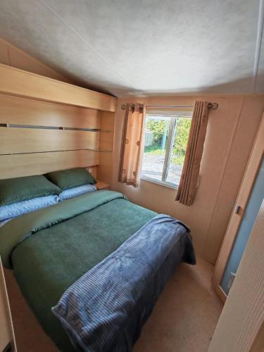 a bed in a small room with a window at Winnie the Mobile Home in Galway