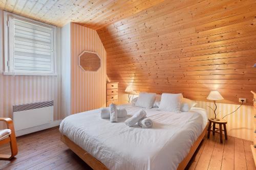 a bedroom with a large white bed with wooden walls at Ker Family in Arzon