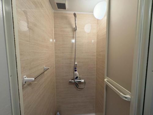a bathroom with a shower stall with a vacuum at Runbull House in Tokyo