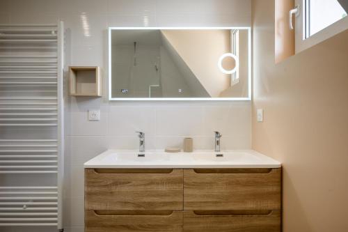a bathroom with a sink and a mirror at Maison La Mirabelle in Thann