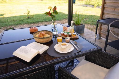 a table with a plate of food and a book at Gite Les Intemporels in Cuisery