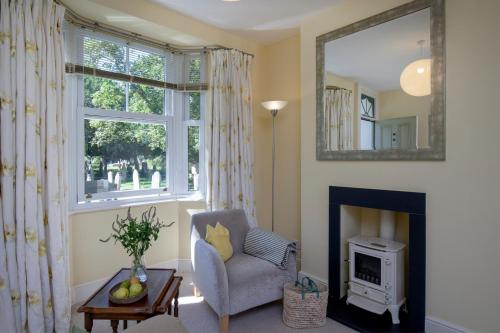 a living room with a chair and a fireplace at 1 Abiff Place in Sidmouth