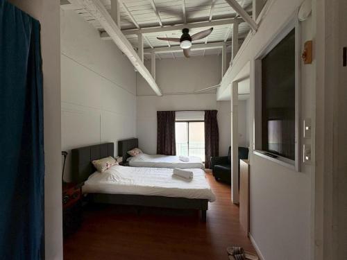 a bedroom with two beds and a ceiling fan at Runbull House in Tokyo