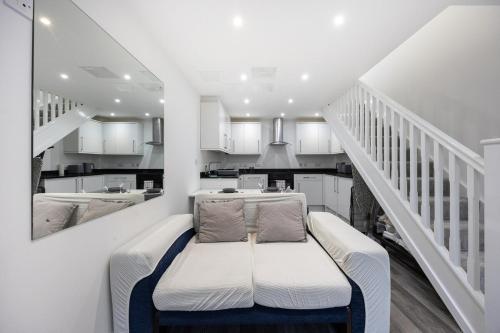 a white room with a bench in the middle of a kitchen at Stylish 2BR Cottage in Chesham in Chesham