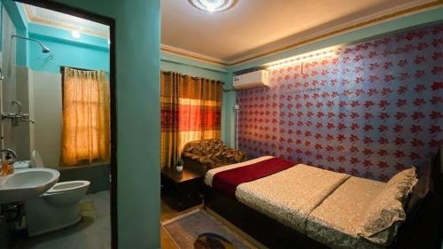 a bedroom with a bed and a sink and a bathroom at Hotel New Bhojpure in Kathmandu