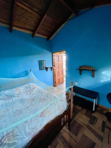 a bedroom with a bed with a blue wall at Jardin Secreto in El Viejo