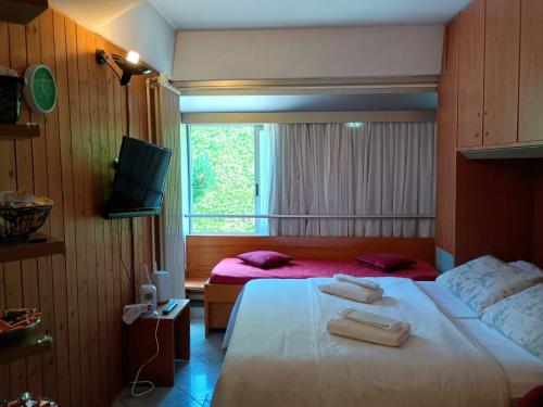 a bedroom with two beds and a window at Monalisa sweet house - Appartamento Marilleva 1400 in Marilleva